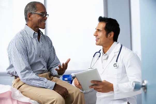 Doctor smiles and talks with patient in doctor's office